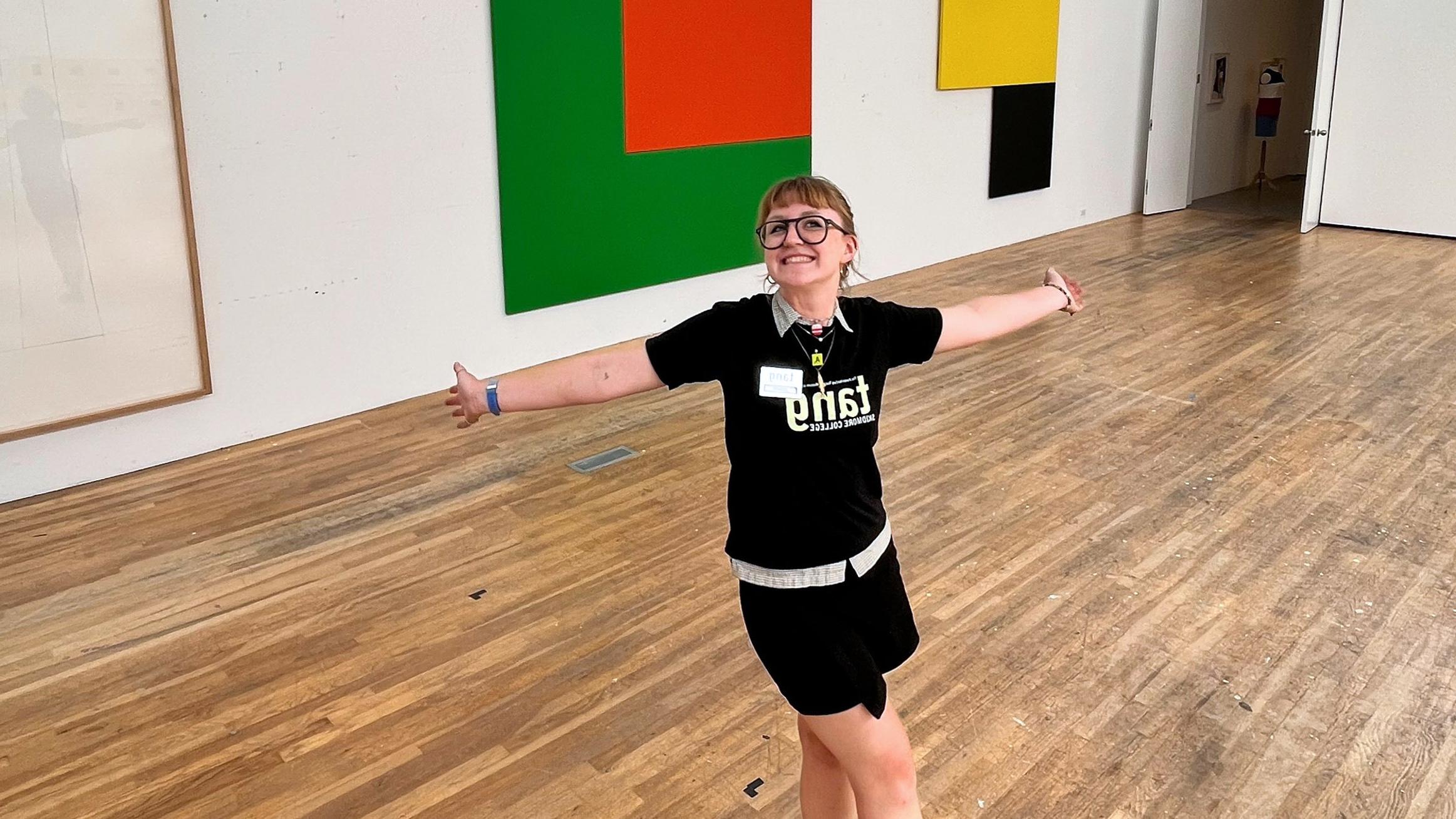 Abigail Svetlik ’24 gestures with outstretched arms to the Ellsworth Kelly Studio behind her.